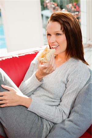 simsearch:6108-05869174,k - Jeune femme mangeant la tranche de pain Photographie de stock - Premium Libres de Droits, Code: 6108-05868956