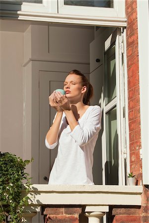 Young woman enjoying sun at window Foto de stock - Sin royalties Premium, Código: 6108-05868979