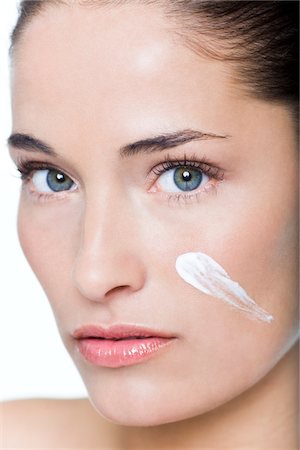soins de peau - Jeune femme avec une crème hydratante sur sa joue Photographie de stock - Premium Libres de Droits, Code: 6108-05869098