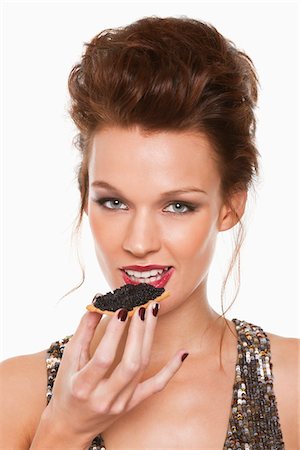 Young woman eating caviar Stock Photo - Premium Royalty-Free, Code: 6108-05869179