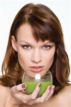 Young woman holding glass of wheatgrass juice Stock Photo - Premium Royalty-Free, Code: 6108-05869117
