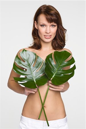 Young woman covering breast with leaves Stock Photo - Premium Royalty-Free, Code: 6108-05869131