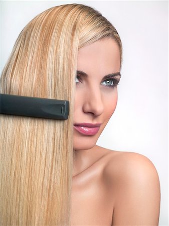soin capillaire - Jeune femme à l'aide du lisseur à cheveux Photographie de stock - Premium Libres de Droits, Code: 6108-05869250