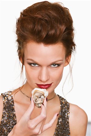 people eating seafood - Young woman eating oyster Stock Photo - Premium Royalty-Free, Code: 6108-05869213