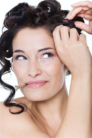 sideways glance - Young woman fixing hair clips Stock Photo - Premium Royalty-Free, Code: 6108-05869234