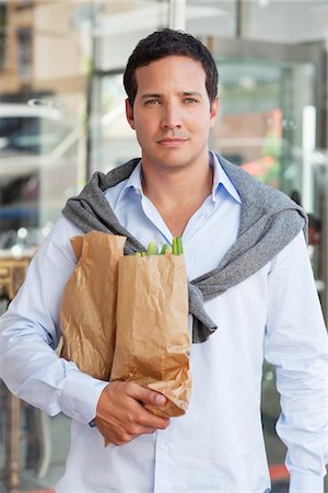 Portrait of a mid adult man holding paper bags full of vegetables Stock Photo - Premium Royalty-Free, Code: 6108-05869596