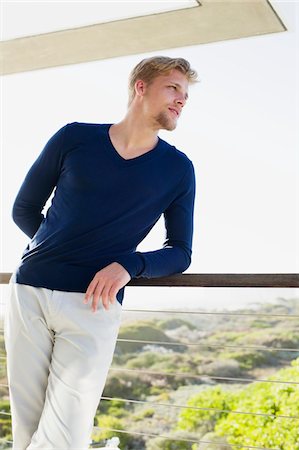 Young man standing at a balcony Foto de stock - Sin royalties Premium, Código: 6108-05869656