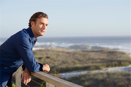 Mid homme adulte accoudée à une balustrade de balcon Photographie de stock - Premium Libres de Droits, Code: 6108-05869663