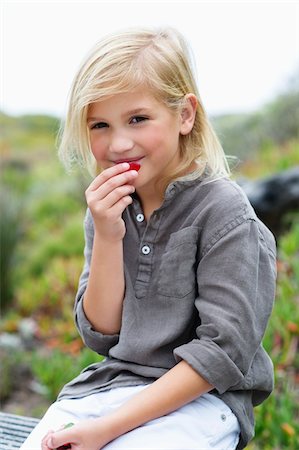 simsearch:6108-05870619,k - Portrait of a girl eating fruit Fotografie stock - Premium Royalty-Free, Codice: 6108-05869703