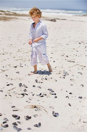 Boy collecting shells on the beach Stock Photo - Premium Royalty-Free, Code: 6108-05869731