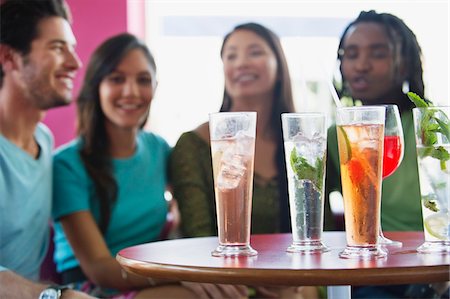 simsearch:6108-06905151,k - Friends sitting in a restaurant with focus on beverage Foto de stock - Sin royalties Premium, Código: 6108-05869868