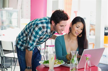 display glass food - Woman using a laptop with her friend in a restaurant Stock Photo - Premium Royalty-Free, Code: 6108-05869832