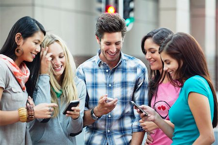 diverse group of friends - Friends using mobile phones outdoors Stock Photo - Premium Royalty-Free, Code: 6108-05869835