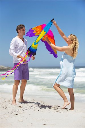 Mid adult couple holding animal shaped kite on the beach Stock Photo - Premium Royalty-Free, Code: 6108-05869940