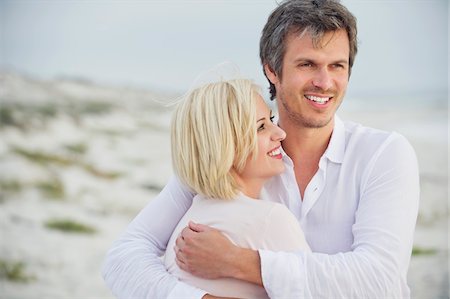 simsearch:6108-05869979,k - Mid adult man embracing his wife and smiling Stock Photo - Premium Royalty-Free, Code: 6108-05869985