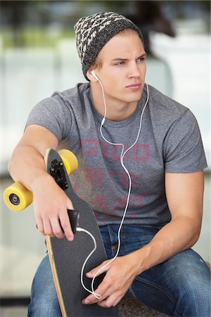 simsearch:6108-08725387,k - Man holding a skateboard and listening to music on a mobile phone Stock Photo - Premium Royalty-Free, Code: 6108-05869921