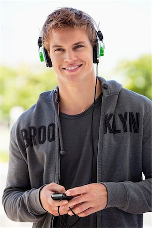 simsearch:6108-08725387,k - Man listening to music with headphones and smiling Stock Photo - Premium Royalty-Free, Code: 6108-05870086
