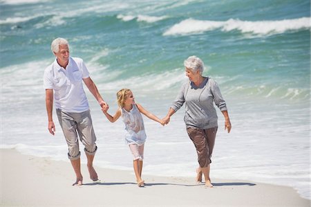 Grandmother and granddaughters walking on the beach together