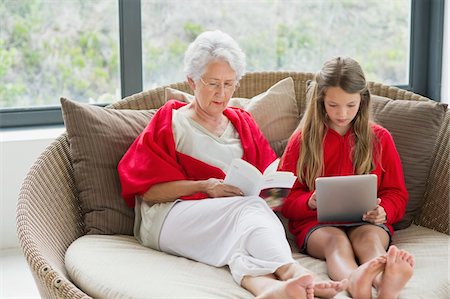 Haute femme lisant un magazine avec sa petite-fille à l'aide d'une tablette numérique Photographie de stock - Premium Libres de Droits, Code: 6108-05870160