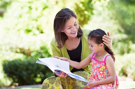 reading book outdoors - Woman with her granddaughter reading a book Stock Photo - Premium Royalty-Free, Code: 6108-05870170