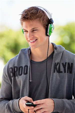standing, headphones - Man listening to music with headphones and smiling Stock Photo - Premium Royalty-Free, Code: 6108-05870115