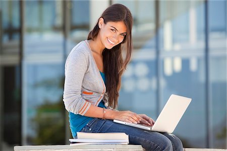 Portrait of a smiling woman using a laptop Stock Photo - Premium Royalty-Free, Code: 6108-05870119