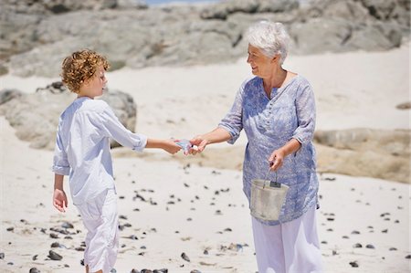 shell - Senior woman with her grandson collecting shell on the beach Foto de stock - Sin royalties Premium, Código: 6108-05870128