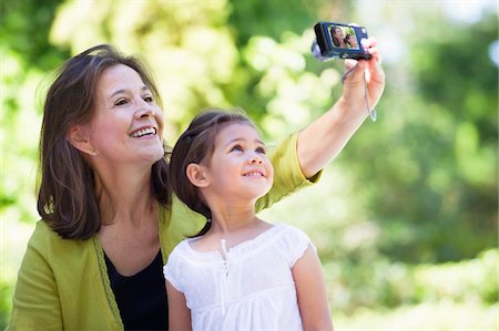 simsearch:6108-05870142,k - Woman and her granddaughter taking photos of themselves Foto de stock - Royalty Free Premium, Número: 6108-05870129