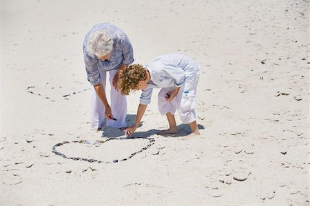 se courber (personne et animal) - Femme senior et son petit-fils, faire une forme de coeur sur la plage Photographie de stock - Premium Libres de Droits, Code: 6108-05870131