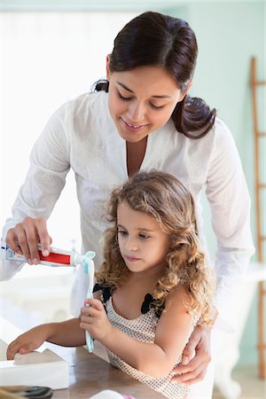 simsearch:6108-05870208,k - Mother applying tooth paste on little girls tooth brush at bathroom Foto de stock - Sin royalties Premium, Código: 6108-05870202