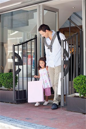 shopping centre exterior - Cute little girl with her father walking out of a shopping mall with shopping bags Stock Photo - Premium Royalty-Free, Code: 6108-05870204