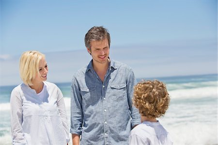 simsearch:6108-05871624,k - Couple talking to their son on the beach Foto de stock - Royalty Free Premium, Número: 6108-05870364