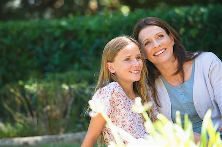 Cute little girl and her mother sitting together in the garden Stock Photo - Premium Royalty-Free, Code: 6108-05870368