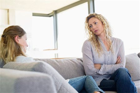 simsearch:6108-05871904,k - Mid adult woman looking at her daughter sitting on a couch Foto de stock - Royalty Free Premium, Número: 6108-05870392