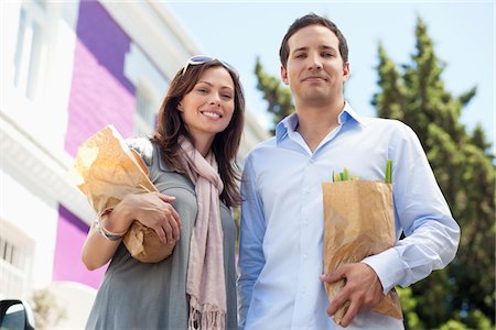 Portrait of a couple standing with paper bags full of vegetables Stock Photo - Premium Royalty-Free, Code: 6108-05870310