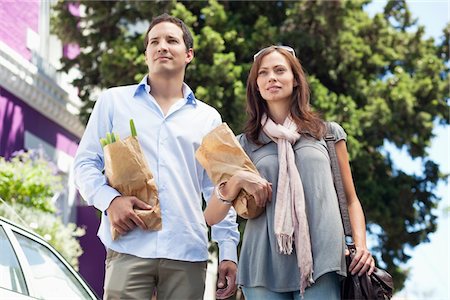 Couple standing with paper bags full of vegetables Stock Photo - Premium Royalty-Free, Code: 6108-05870335