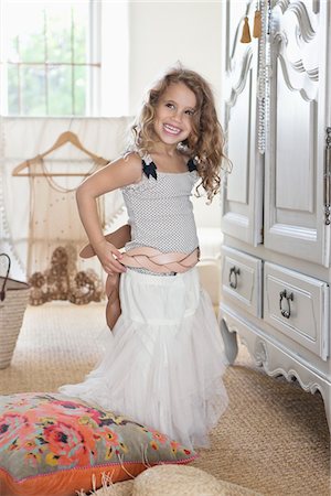sonrisas sardónicas - Cute little girl getting dressed like her mother in oversized clothes Foto de stock - Sin royalties Premium, Código: 6108-05870467