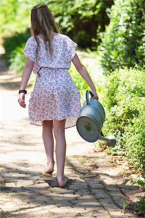 plantation (exploitation agricole) - Vue arrière d'une petite fille d'arrosage pour les plantes à l'extérieur Photographie de stock - Premium Libres de Droits, Code: 6108-05870499