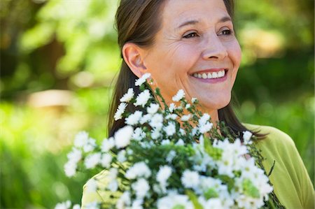 simsearch:6108-05871799,k - Woman holding a bunch of flowers outdoors Stock Photo - Premium Royalty-Free, Code: 6108-05870544