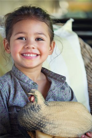 phoney smile - Portrait of a little girl holding model of turkey Stock Photo - Premium Royalty-Free, Code: 6108-05870563