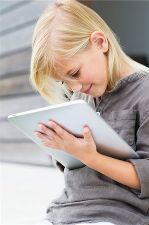 Girl using a digital tablet Foto de stock - Sin royalties Premium, Código: 6108-05870570