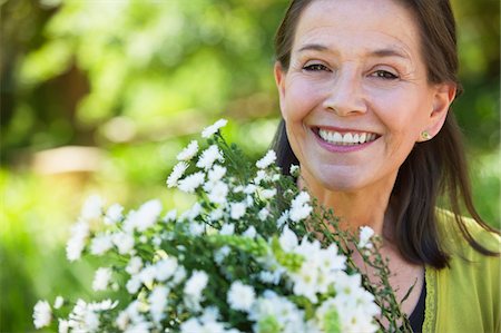 simsearch:6108-05871799,k - Portrait of a woman holding a bunch of flowers outdoors Stock Photo - Premium Royalty-Free, Code: 6108-05870522