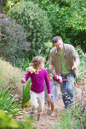 simsearch:6108-05871918,k - Père de deux enfants marchant dans un jardin Photographie de stock - Premium Libres de Droits, Code: 6108-05870679
