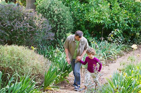 father son caucasian walking two people casual clothing - Father and son walking in a garden Stock Photo - Premium Royalty-Free, Code: 6108-05870687