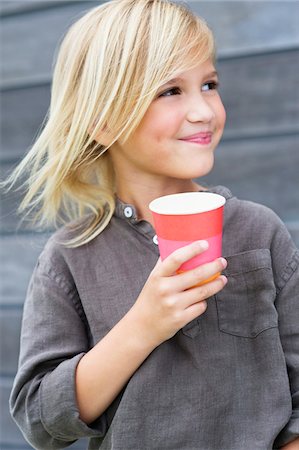 Girl holding a coffee cup and smiling Stock Photo - Premium Royalty-Free, Code: 6108-05870604