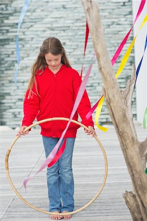 Girl holding a plastic hoop Stock Photo - Premium Royalty-Free, Code: 6108-05870614