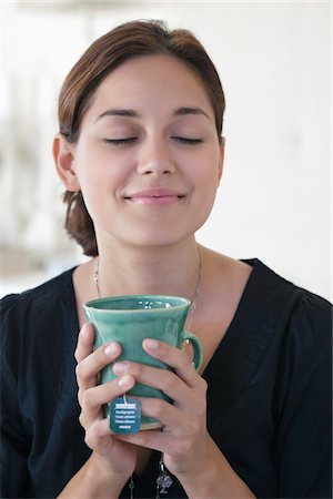 sachet de thé - Jeune femme tenant la tasse de thé avec ses yeux fermés Photographie de stock - Premium Libres de Droits, Code: 6108-05870766