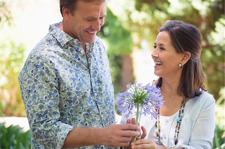 parent care older - Man giving flower to his mother and smiling Stock Photo - Premium Royalty-Free, Code: 6108-05870739