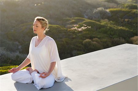 Mid adult woman meditating Stock Photo - Premium Royalty-Free, Code: 6108-05870857