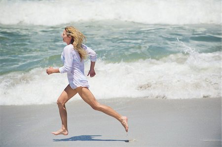 running to surf - Side profile of a beautiful woman running on the beach Foto de stock - Sin royalties Premium, Código: 6108-05870855